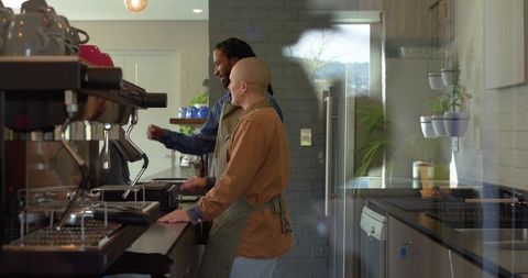 Baristas collaborating behind espresso counter preparing specialty coffee in modern cafe