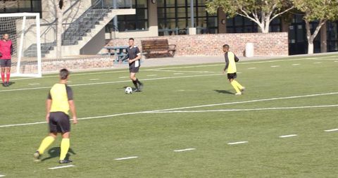 Soccer team strategizing and passing on field for goal attempt