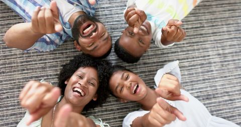 Happy family bonding lying on striped rug smiling