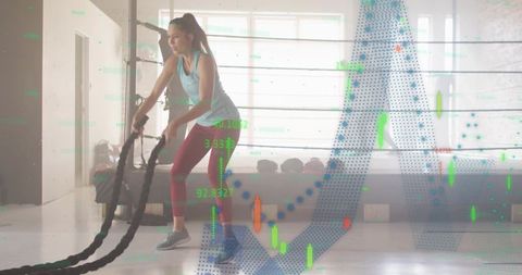 Woman swinging battle ropes in boxing ring with data overlay for high-intensity training