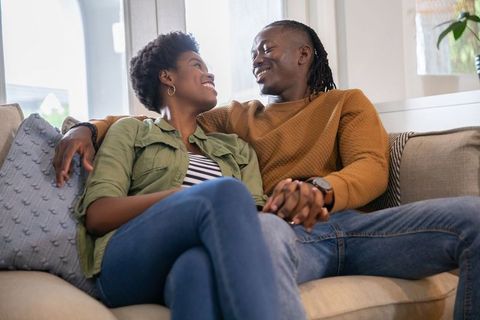 Happy Couple Sitting on Couch at Home Relaxing Together