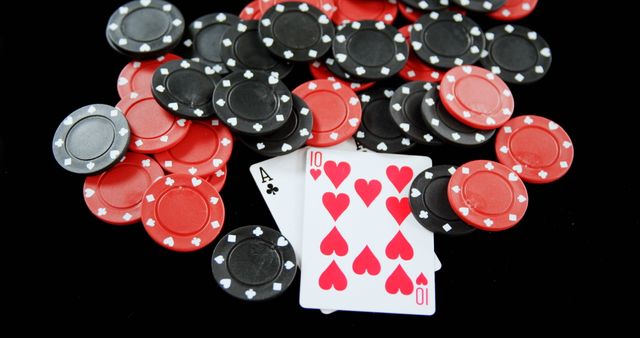Close-up view of stacked poker chips, predominantly black and red, surrounding an ace of clubs and ten of hearts playing cards on a black background. Ideal for advertisements related to casinos, gambling, card games, poker tournaments, or online gaming platforms.