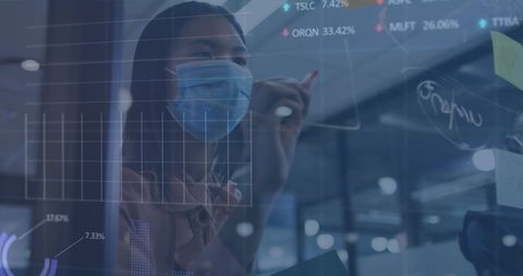 Businesswoman in face mask analyzing data in modern office