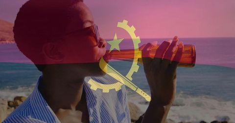 Woman enjoying drink by rocky coast with angola flag overlay
