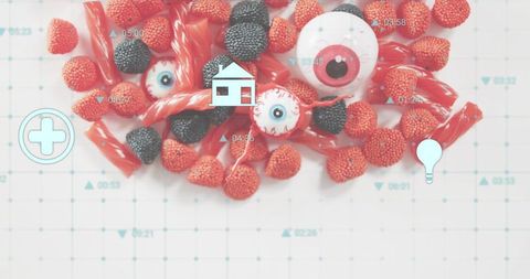 Candy flatlay with red raspberry drops, blackberry candies, glossy licorice and eyeballs