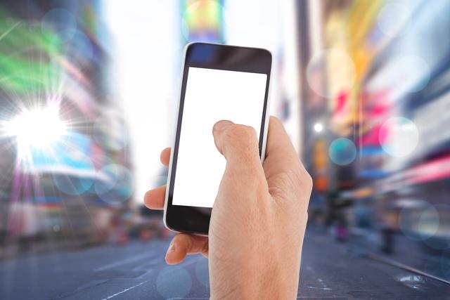This image shows a person's hand holding a smartphone with a blank screen, set against the backdrop of a blurred cityscape with bright lights. The composition emphasizes urban living and technology, making it perfect for illustrating concepts like mobile applications, digital communication, or modern urban lifestyle. It can be used in advertisements for mobile applications, digital services, or urban lifestyle blogs.
