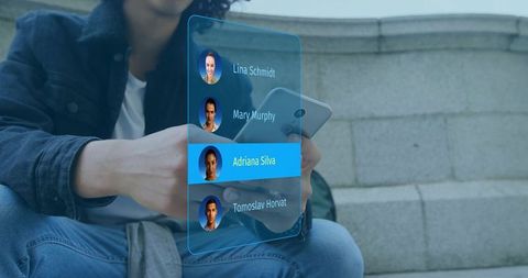 Holding smartphone and selecting contact on holographic mobile interface on urban steps