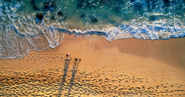 Aerial View of Two People Relaxing on Scenic Beach with Crystal Clear Waters - Download Free Stock Images Pikwizard.com