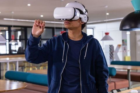 Young man testing virtual reality headset in modern coworking space for immersive tech demo