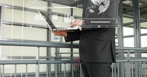 Executive using laptop with holographic analytics overlay on modern office mezzanine