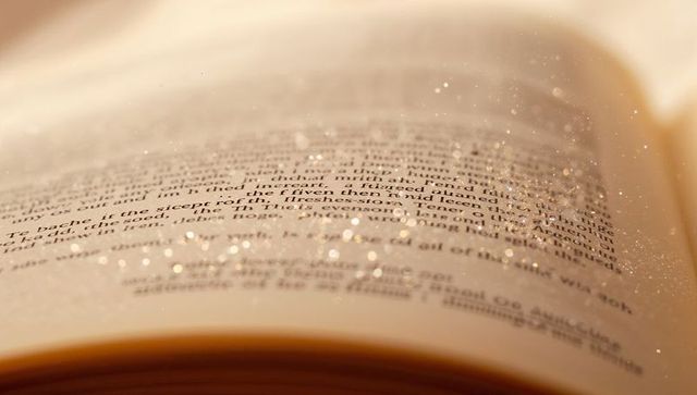 Sepia open book with sparkling dust, close-up printed text and macro typographic texture