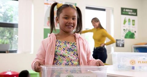 Smiling Student Participating in Classroom Recycling Activity