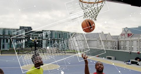Rooftop basketball players reaching for slam dunk with futuristic data overlay