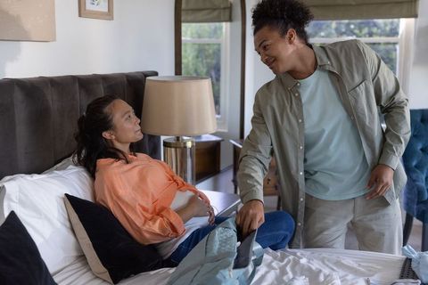 Expectant couple sharing tender moment in bedroom offering pregnancy support and care