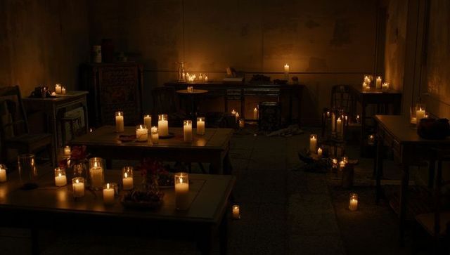 Dimly lit room with candles creating ritualistic ambiance