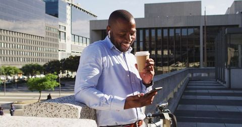 Businessman Enjoying Coffee and Connecting with Smartphone Outdoors