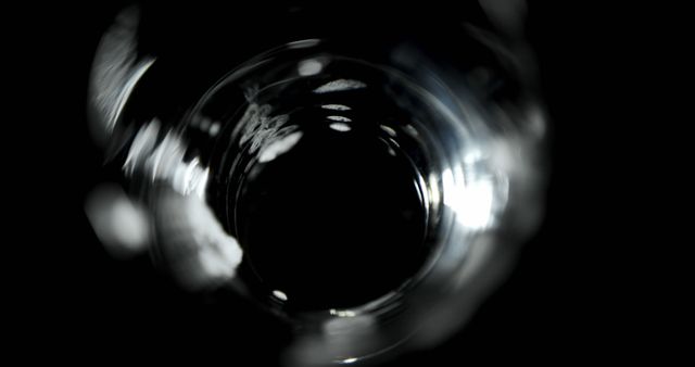 Close-up view of crystal glass showing abstract bokeh effects and reflections. Image captures intricate details and blurred effect within circles, creating a sense of mystery and elegance. Suitable for backgrounds, artistic projects, and design inspiration requirements.