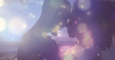Romantic Couple Embracing at Sunset by the Sea with Magical Lights - Download Free Stock Images Pikwizard.com