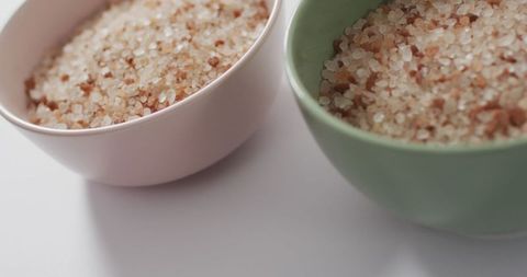 Pink himalayan salt in ceramic bowls on neutral background