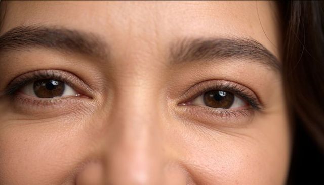 Intimate closeup of brown eyes and lashes capturing light, natural skin texture detail