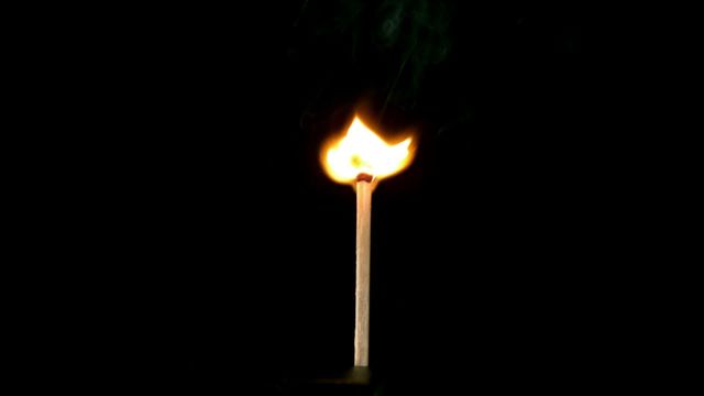 A matchstick burning with a bright flame against a black background, captured in slow motion. The rising smoke adds a dramatic effect. This video is perfect for designs related to fire safety, ignition, or simply for creating a warm, intense visual impact in presentations, advertising materials, or educational resources on fire and combustion.