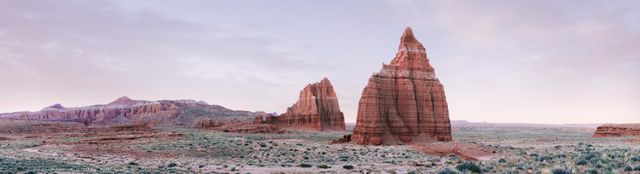 This beautiful panoramic image captures the extraordinary sandstone formations of Cathedral Valley in Utah at sunrise. Ideal for use in travel brochures, nature magazines, or as a gorgeous backdrop to emphasize themes of natural beauty, serenity, and adventure in outdoor and travel-related content.
