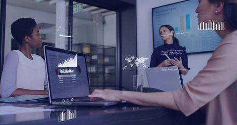 Presenting team reviewing digital analytics dashboards in modern glass boardroom