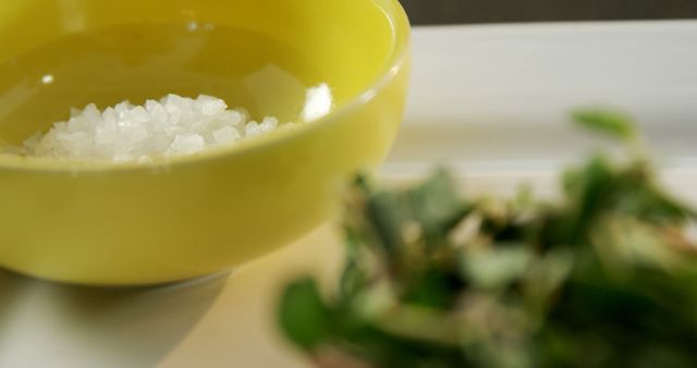 Close-Up of Sea Salt in Yellow Bowl with Fresh Herbs in Soft Focus - Download Free Stock Images Pikwizard.com