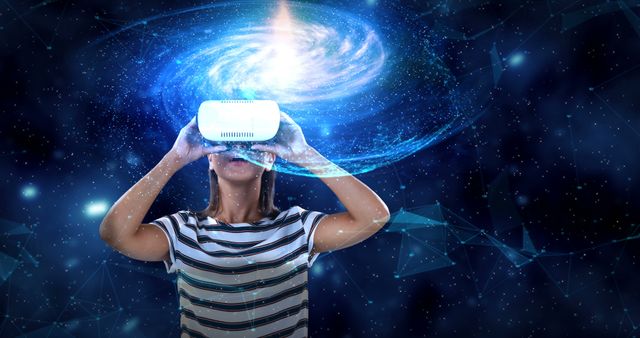 A young woman uses a virtual reality headset, appearing to interact with a digital galaxy simulation. The image is ideal for concepts related to digital technology, futuristic innovations, virtual experiences, space exploration, and educational tools. It can be used in promotional materials for tech companies, VR development, digital learning platforms, and space-themed events.