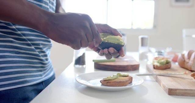 Man Preparing Avocado on Toast in Bright Modern Kitchen - Download Free Stock Images Pikwizard.com