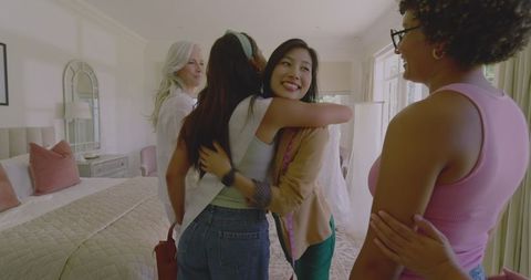 Bride Sharing Wedding Dress with Friends in Cozy Bedroom Celebrating Friendship