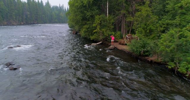 Person in Red Jacket Fishing on River Bank in Forest - Download Free Stock Images Pikwizard.com