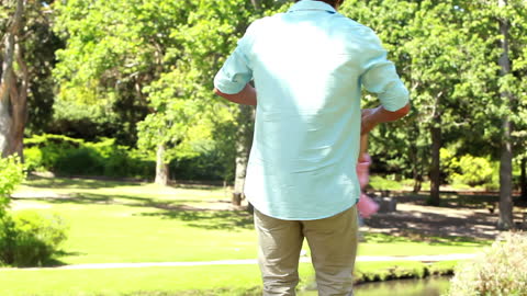 Father Twirling Little Daughter in Park