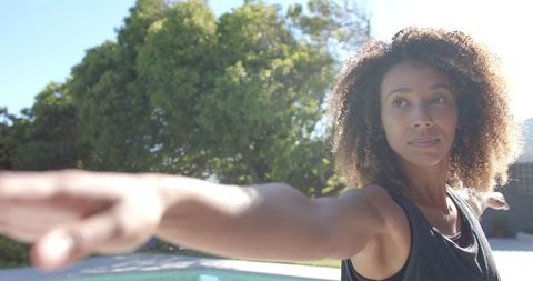 Calm Woman Practicing Yoga Outdoors in Sunlit Garden