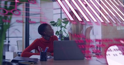 Collaborating over laptop with pink-glass notes in modern office creative mentoring moment