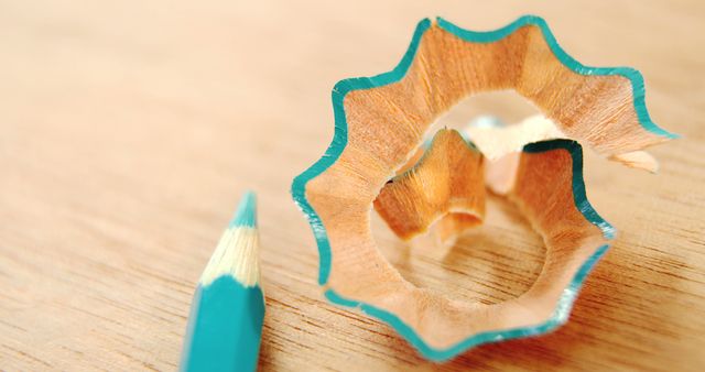 Close-up of turquoise pencil shavings and sharpened pencil on wooden surface - Download Free Stock Images Pikwizard.com