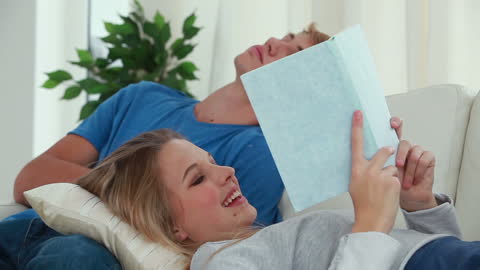 Couple Relaxing in Living Room with Book and Nap