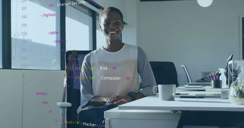 Smiling professional woman coding in open office workspace