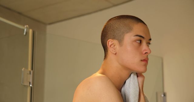 Serene Person with Shaved Head in Bathroom Holding Towel - Download Free Stock Images Pikwizard.com