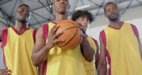 Basketball Team Bonding on Indoor Court in Yellow-Red Jerseys