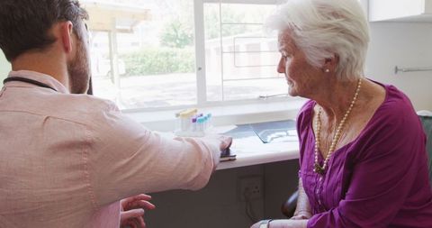 Doctor Consulting Elderly Woman in Retirement Home during Pandemic