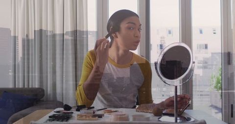 Person applying makeup over urban cityscape reflection