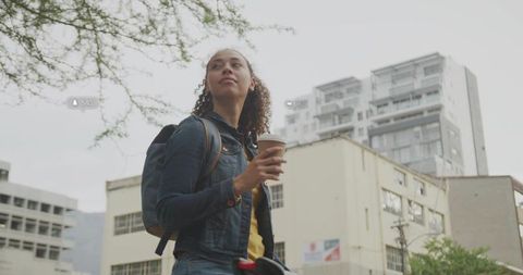 Woman With Coffee on Urban Street Looking Ahead