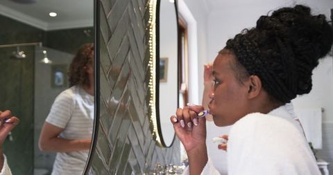 Couple Practicing Morning Dental Hygiene in Modern Bathroom