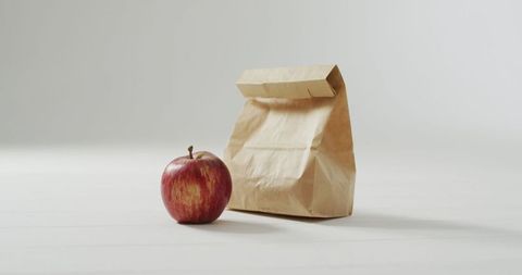 Minimalist Lunch With Brown Bag and Fresh Apple on White Surface - Download Free Stock Images Pikwizard.com