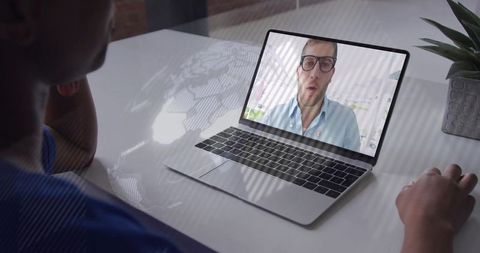 Woman participating in remote video call with professional consultant on laptop at minimalist desk