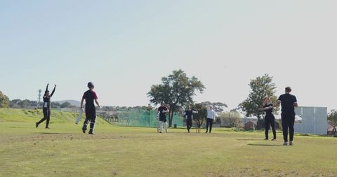 Cricketers Gathering on Field for Match Under Clear Sky