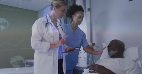 Doctor pointing while nurse supporting patient and checking tablet in hospital