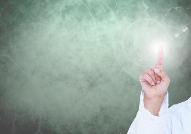 Doctors hand touching a lens flare against green mottled background
