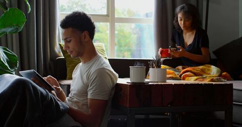 Young Adults Using Digital Devices at Home in Relaxing Atmosphere - Download Free Stock Images Pikwizard.com